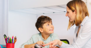 Understanding-Autism-Level-3: Educator supporting a child with autism during a focused learning activity.