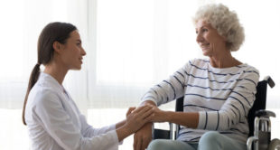 Adult support worker providing compassionate care and assistance to an elderly woman in a supportive care setting.